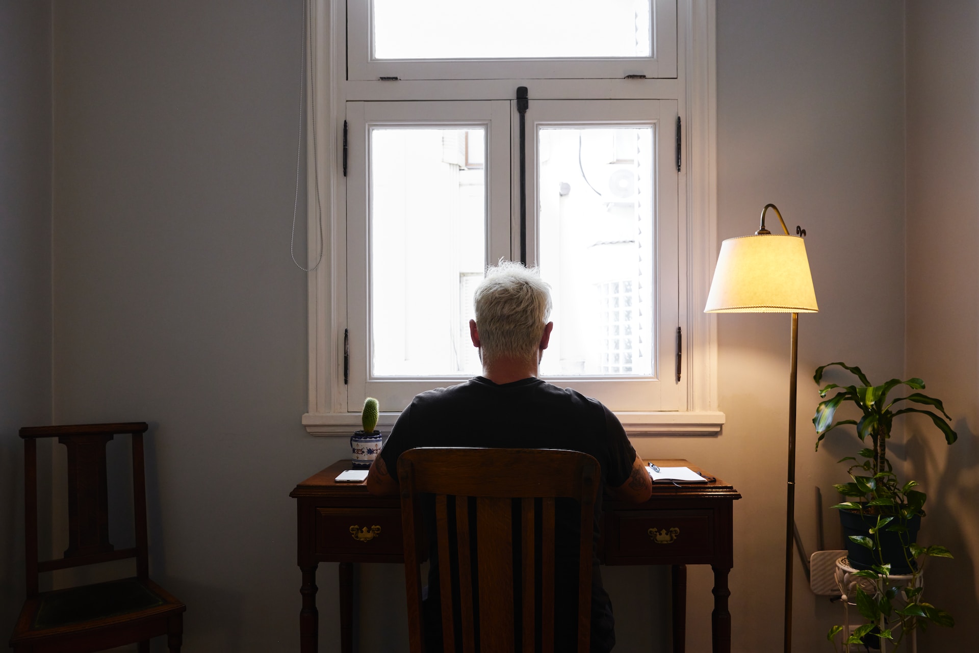 Une personne étudie devant une fenêtre.