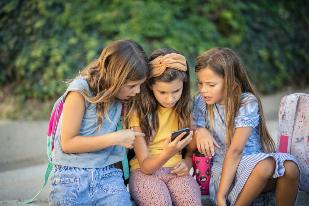 Un groupe d'écolières consultent leur smartphone.