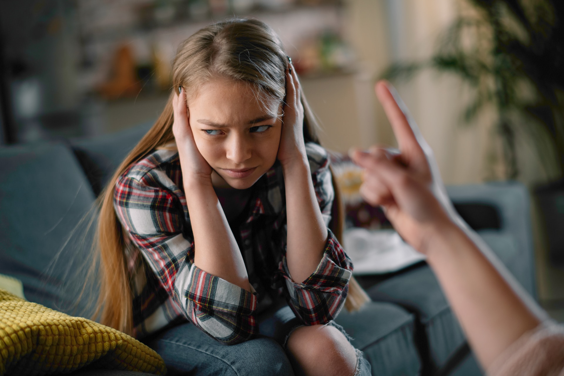 Une fille se protège devant un adulte en colère.
