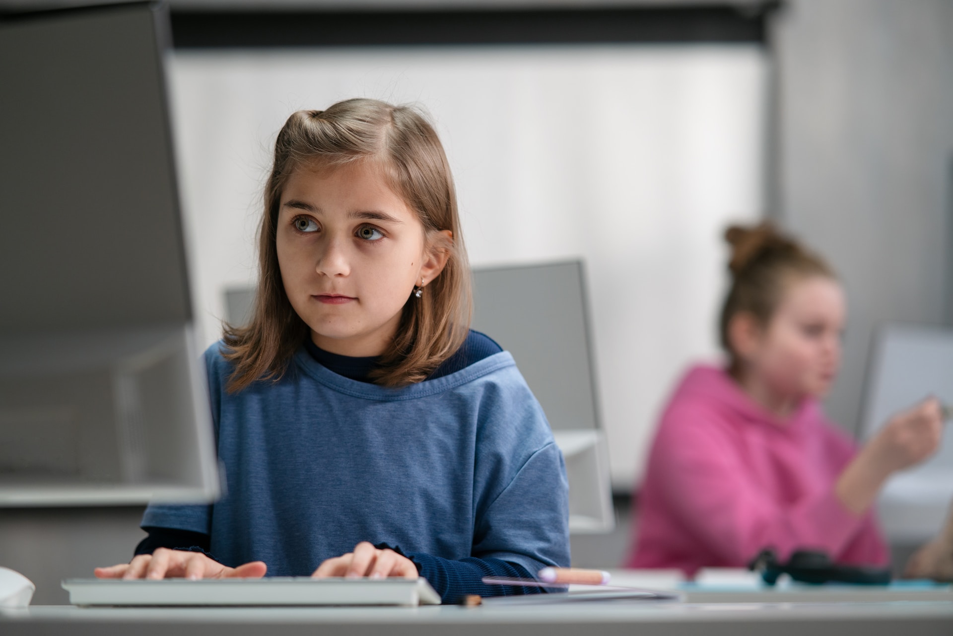Une élève travaille sur informatique dans une salle de classe.