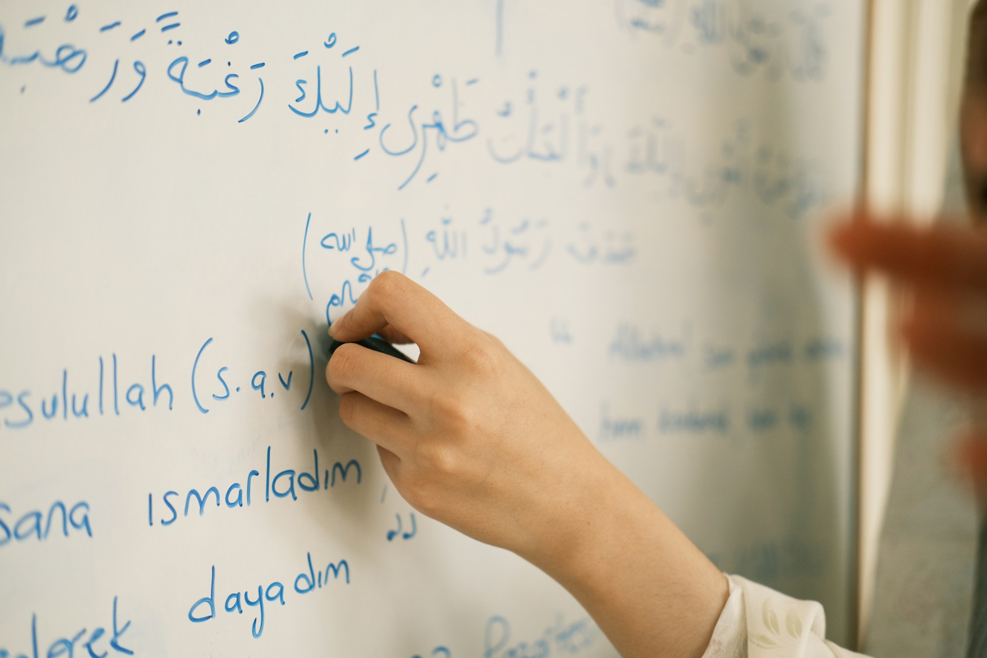 Une personne en train d'apprendre à écrire en arabe.