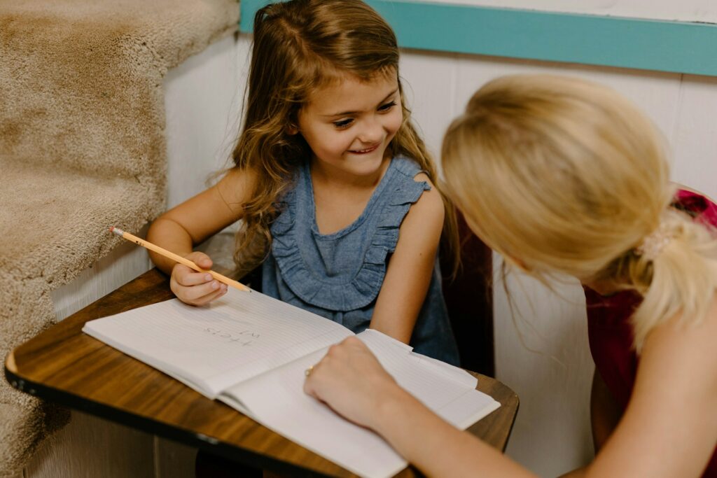 Une enseignante avec une petite fille sur l'aide aux devoirs.