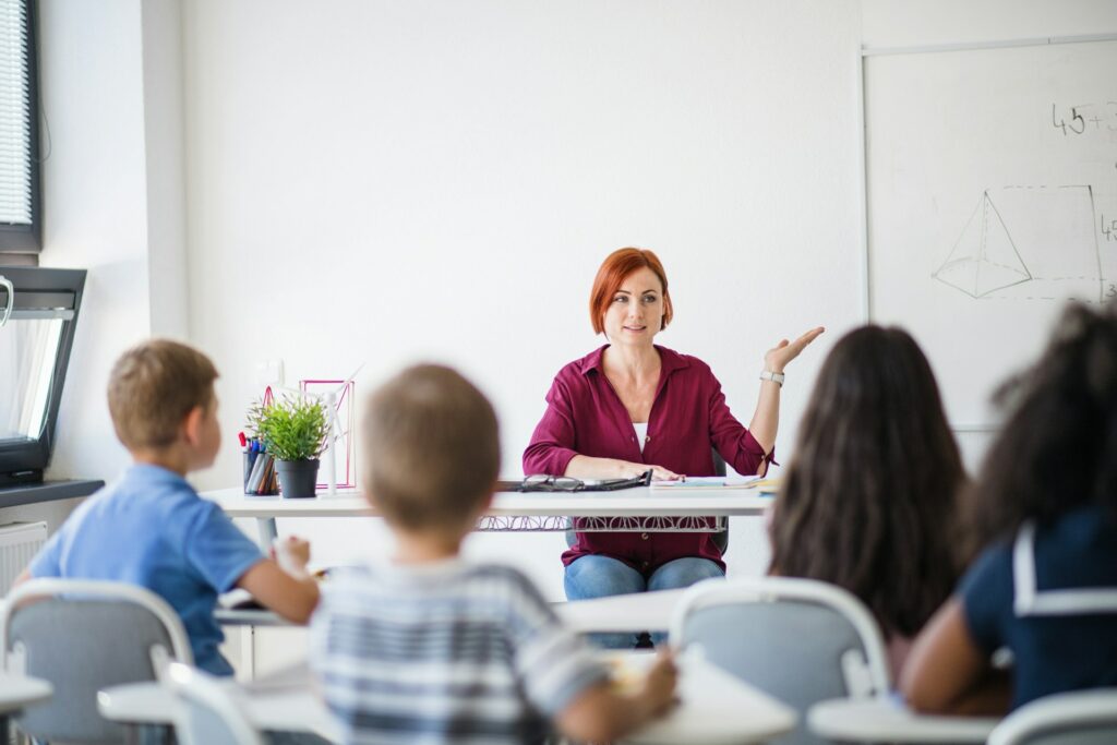 Une professeure donne un cours à des petits élèves de niveau primaire.