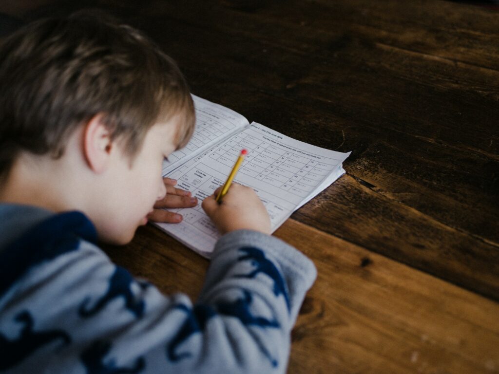 Un petit garçon travaille sur un cahier.