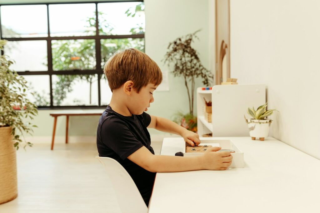 Un petit garçon joue avec un jouet en bois sur une table.