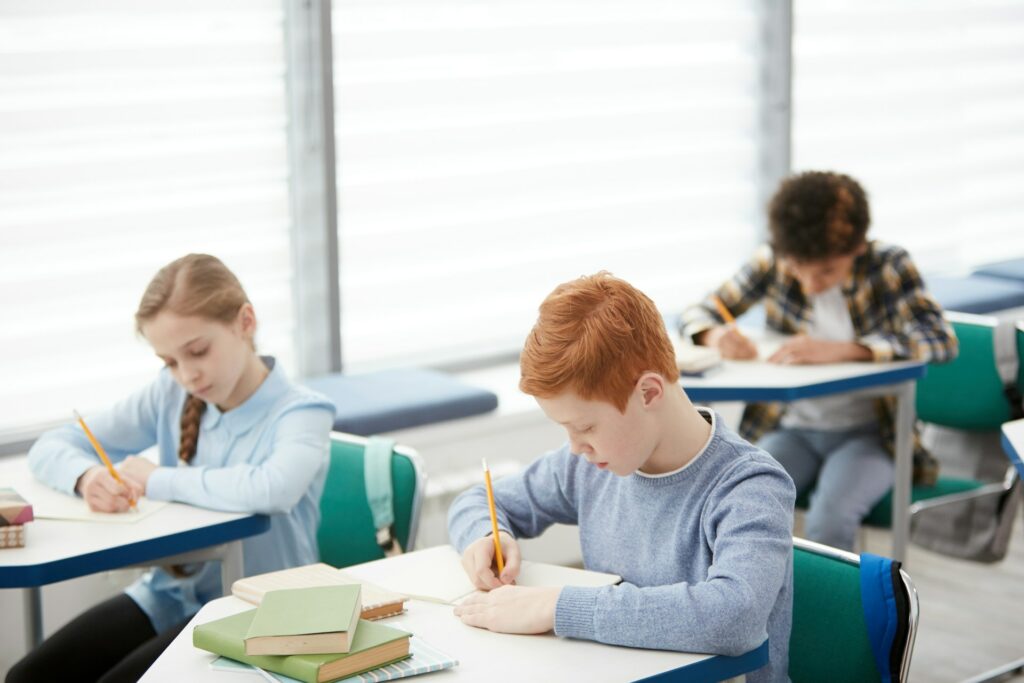 Des élèves écrivent dans une salle de cours.