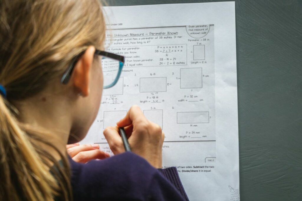 Une élève fait des exercices en sciences sur un papier.