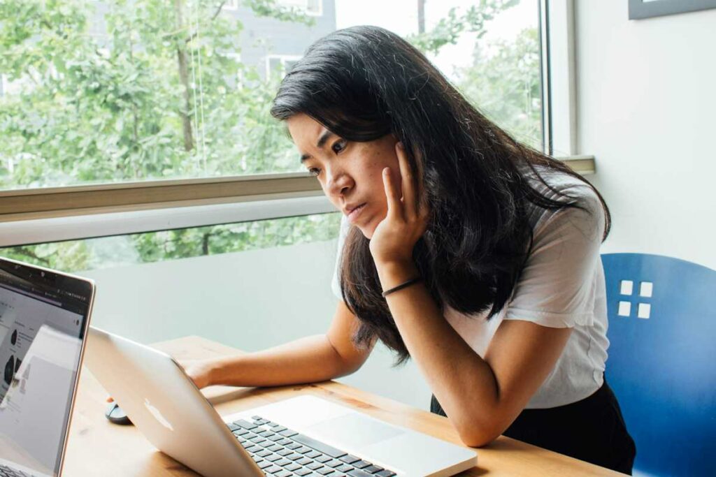 Une jeune femme en train de travailler devant son écran.