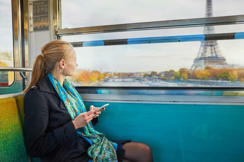 Vue de profil d'une passagère dans une rame traversant la Seine, devant la tour Eiffel.