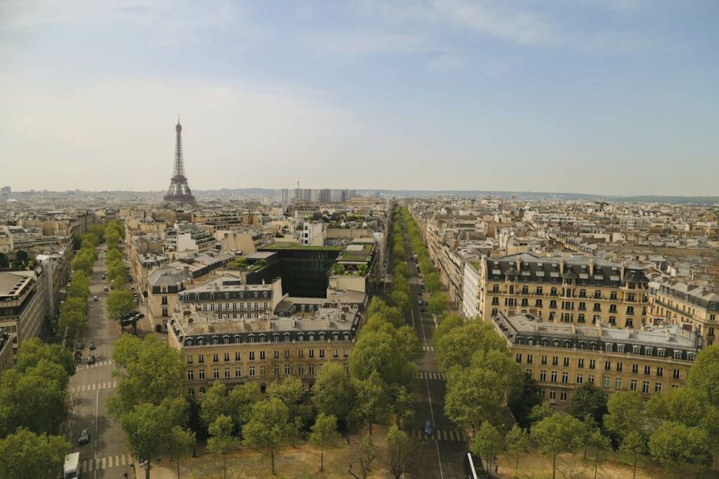 Vue sur les toits de Paris avec la Tour Eiffel en arrière-plan, par un jour ensoleillé.