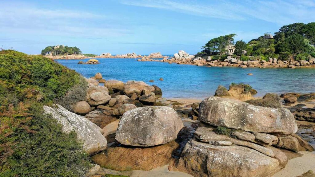 Vue d'une plage bretonne avec l'eau turquoise et de jolies roches.