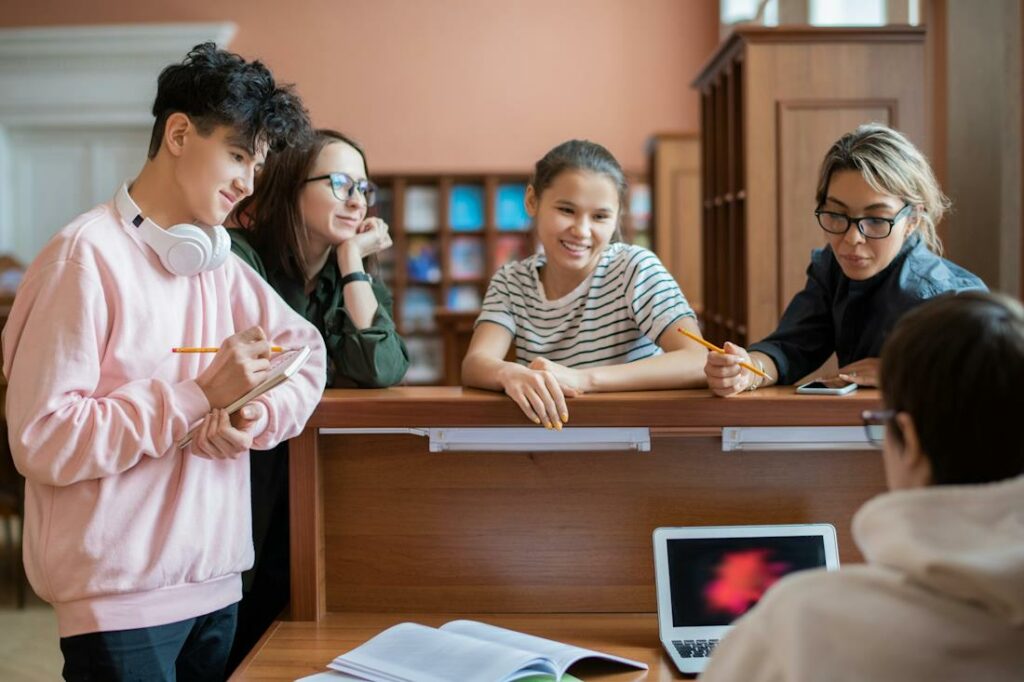 Des jeunes étudiants sourient et travaillent ensemble.