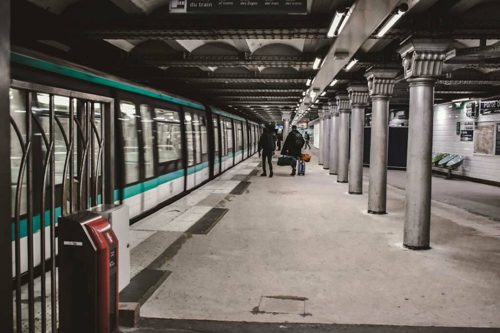 Vue des couloirs du métro parisien avec des quais vides et une rame fermée.