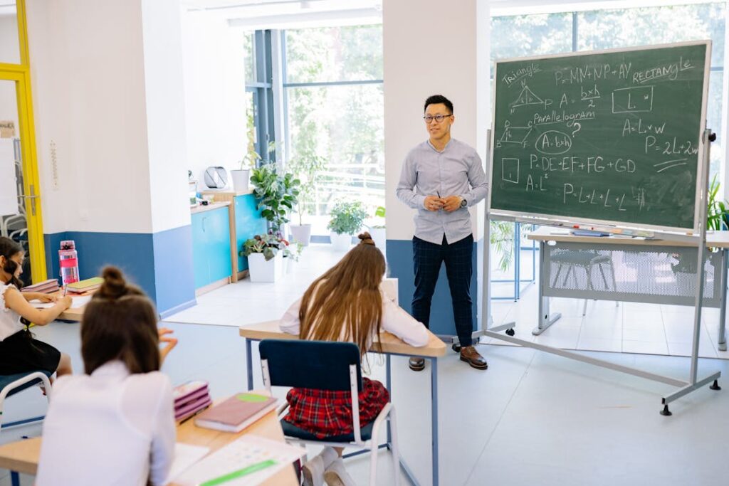 Une classe de maths avec le professeur debout, et les élèves assis en train de travailler.