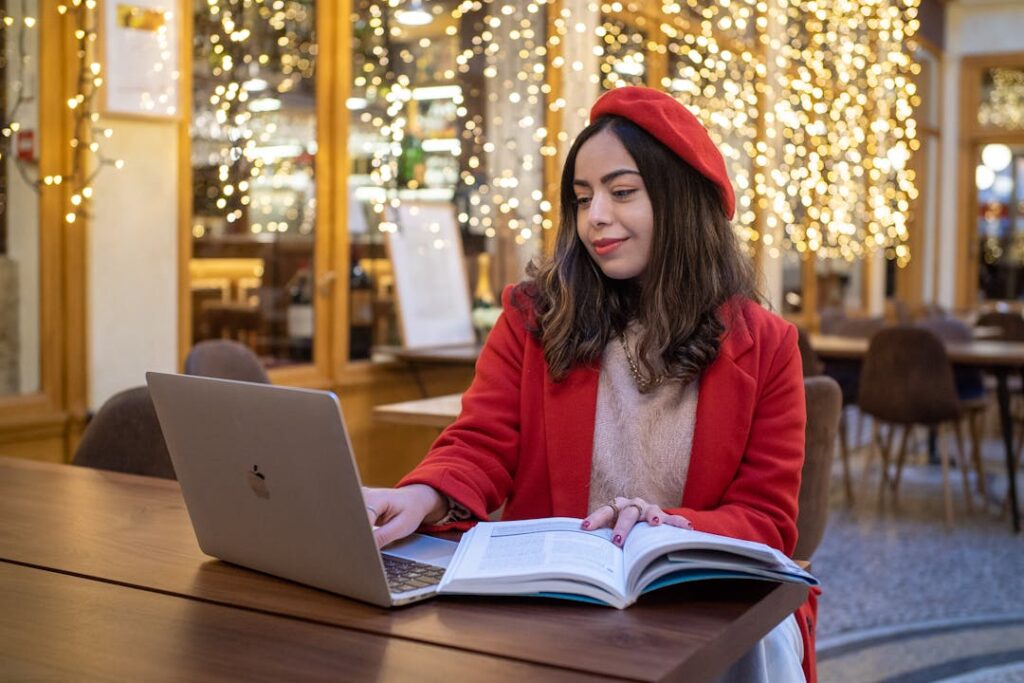 Une jolie femme vêtue de rouge travaille sur un ordinateur dans une pièce où il fait froid.