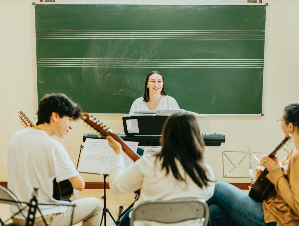 Une professeure de musique sourit devant ses étudiants.