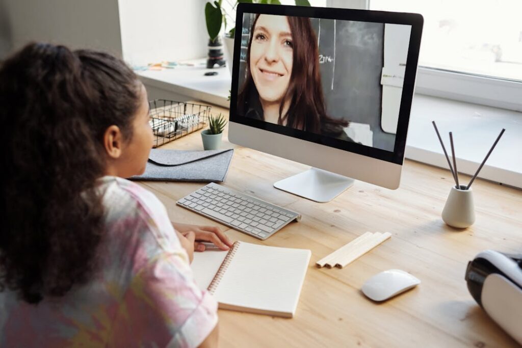 Une petite fille prend une leçon à distance par ordinateur.