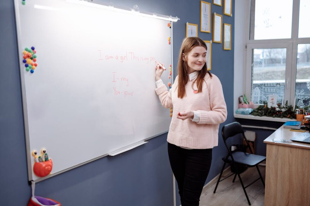 Une professeure sourit devant ses élèves, dans une classe.