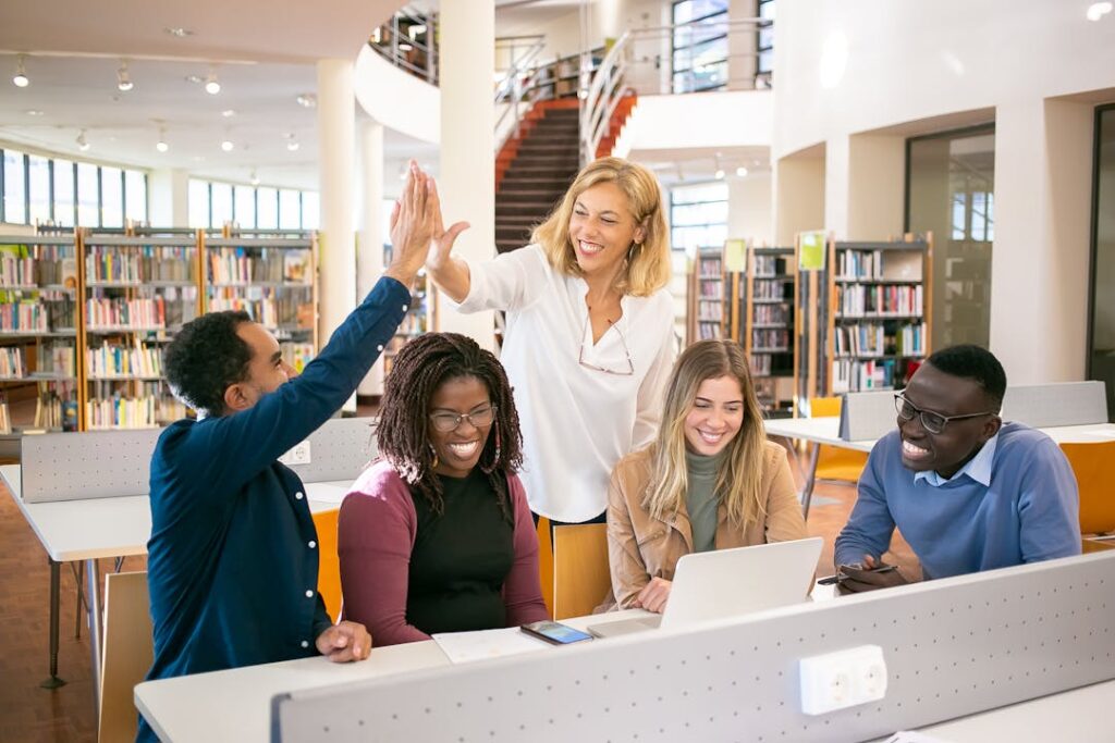 Des étudiants se tapent la main pour se féliciter dans une bibliothèque.