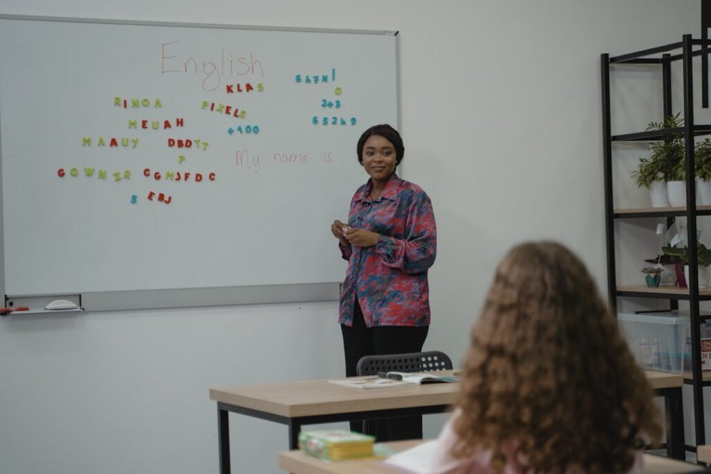 Une enseignante se tient debout, en classe face à ses élèves.