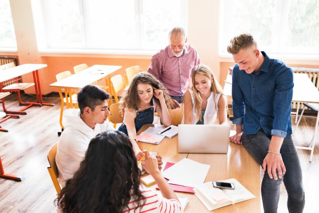 Des étudiants en train de travailler avec leur prof de philo.