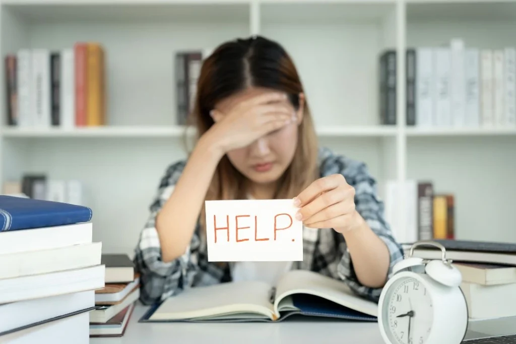 Une jeune femme semble désemparée devant un livre.