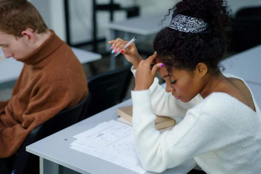Une jeune étudiante est en train de composer sur un sujet lors d'un examen sur table.