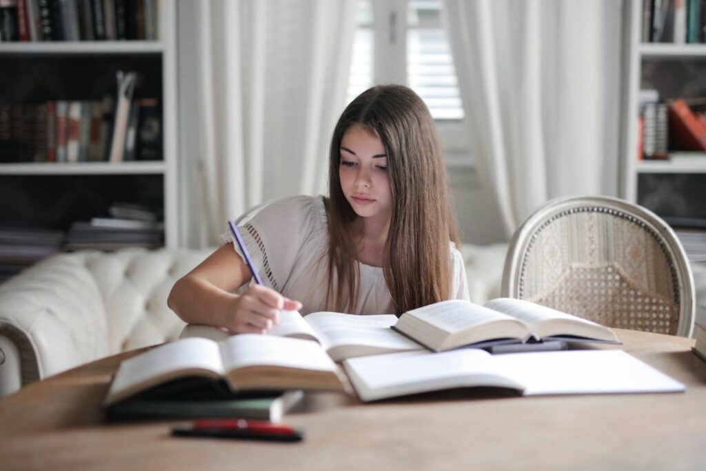 Une adolescente photographiée en train de faire ses devoirs à la maison.