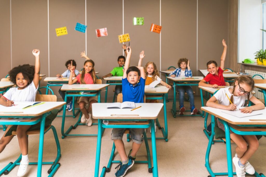 Une salle de classe de CM2 en train de lever la main.