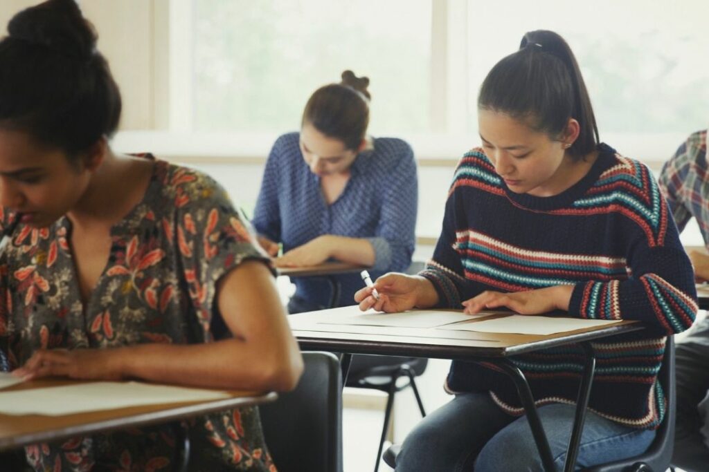 Des élèves d'une classe sont en train de travailler sur leur table, en individuel.