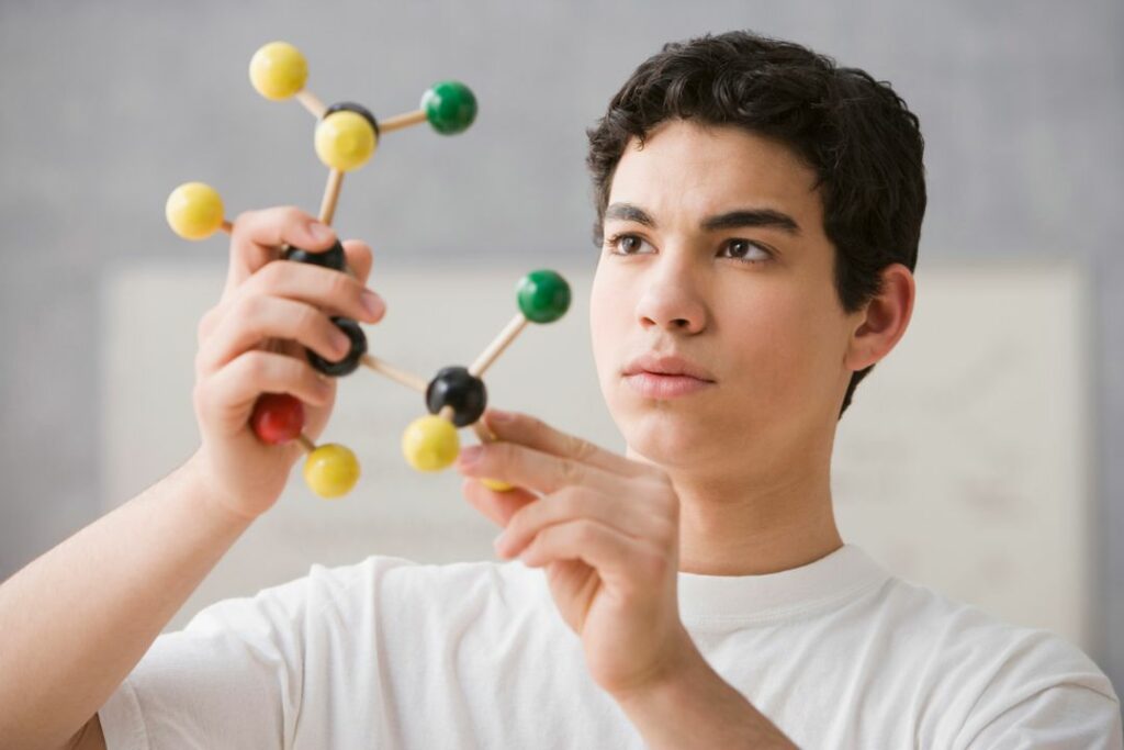 Un élève en train de manipuler une structure d'atome.