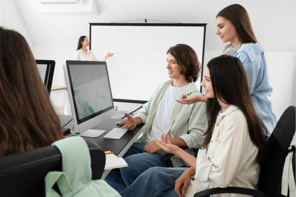 Des élèves en train d'étudier derrière un ordinateur.