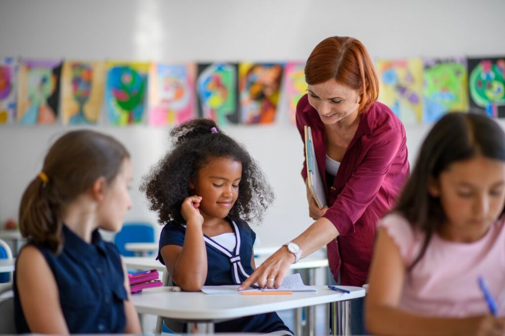 Une professeure montre une solution à une de ses élèves.