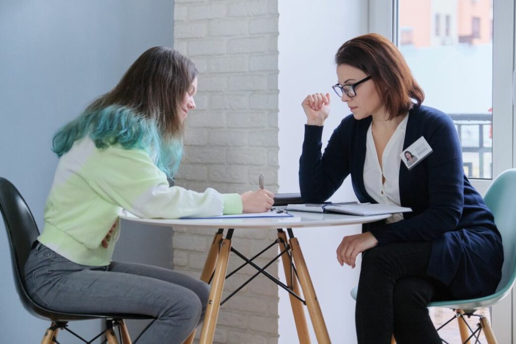 Lycéenne rédigeant son CV avec l'aide d'une conseillère.